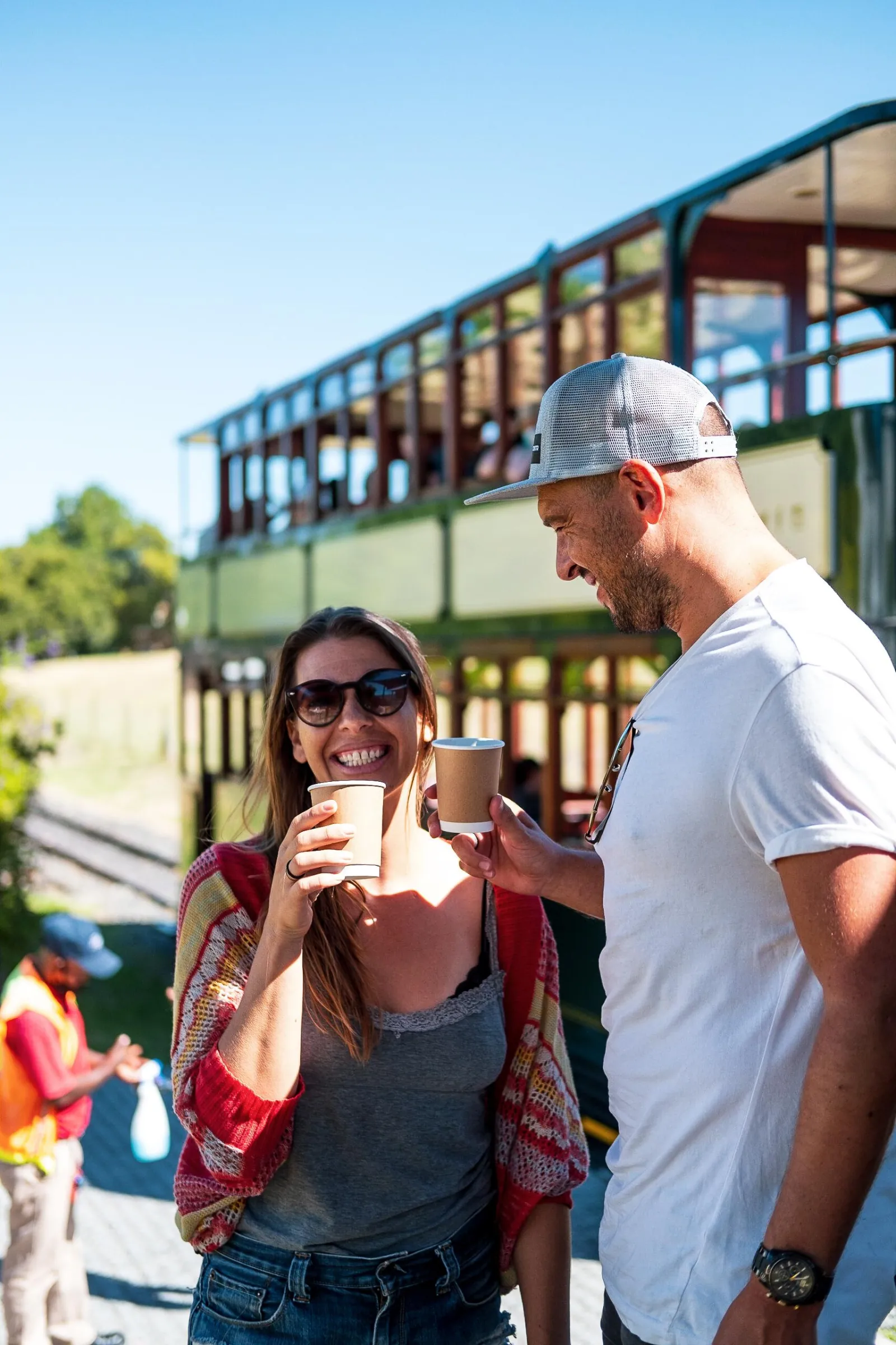 Two guests with a glass of wine at a stop on the Franschhoek Wine Tram route