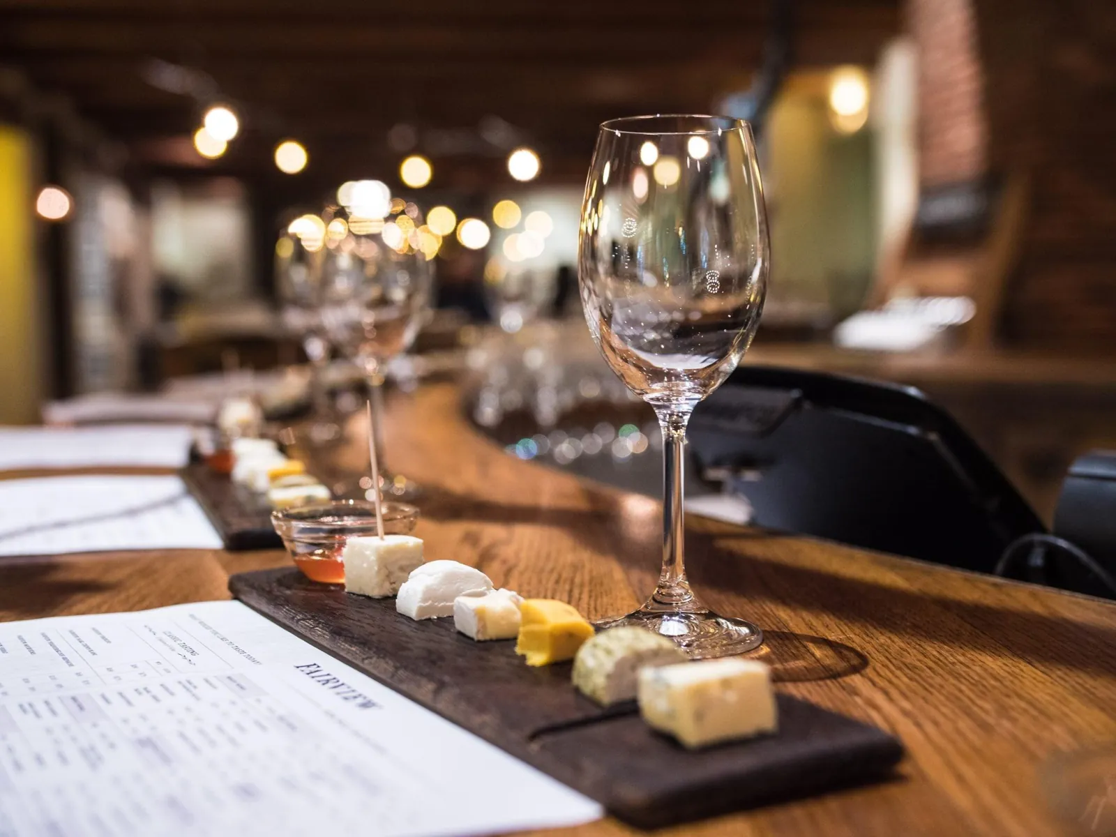 A wine tasting flight with cheese and charcuterie pairings on a wooden board