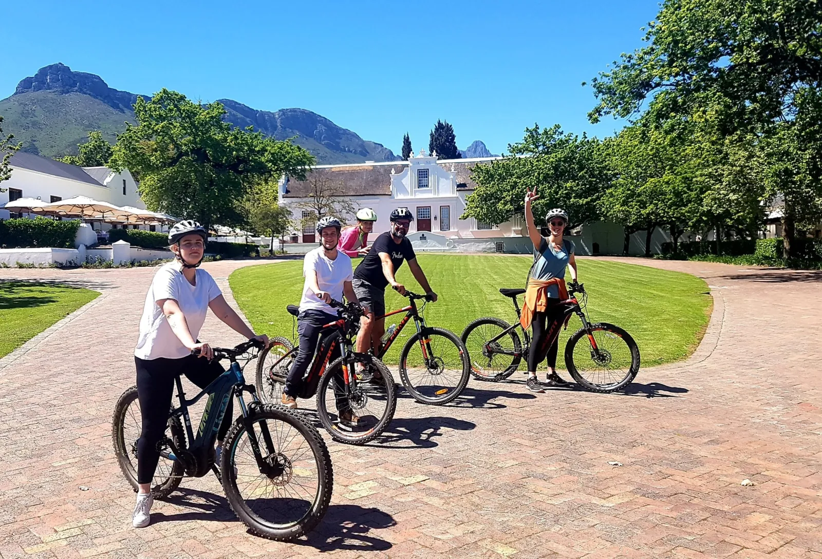 Cyclists gathering with their bikes on the lawn of a Stellenbosch wine estate