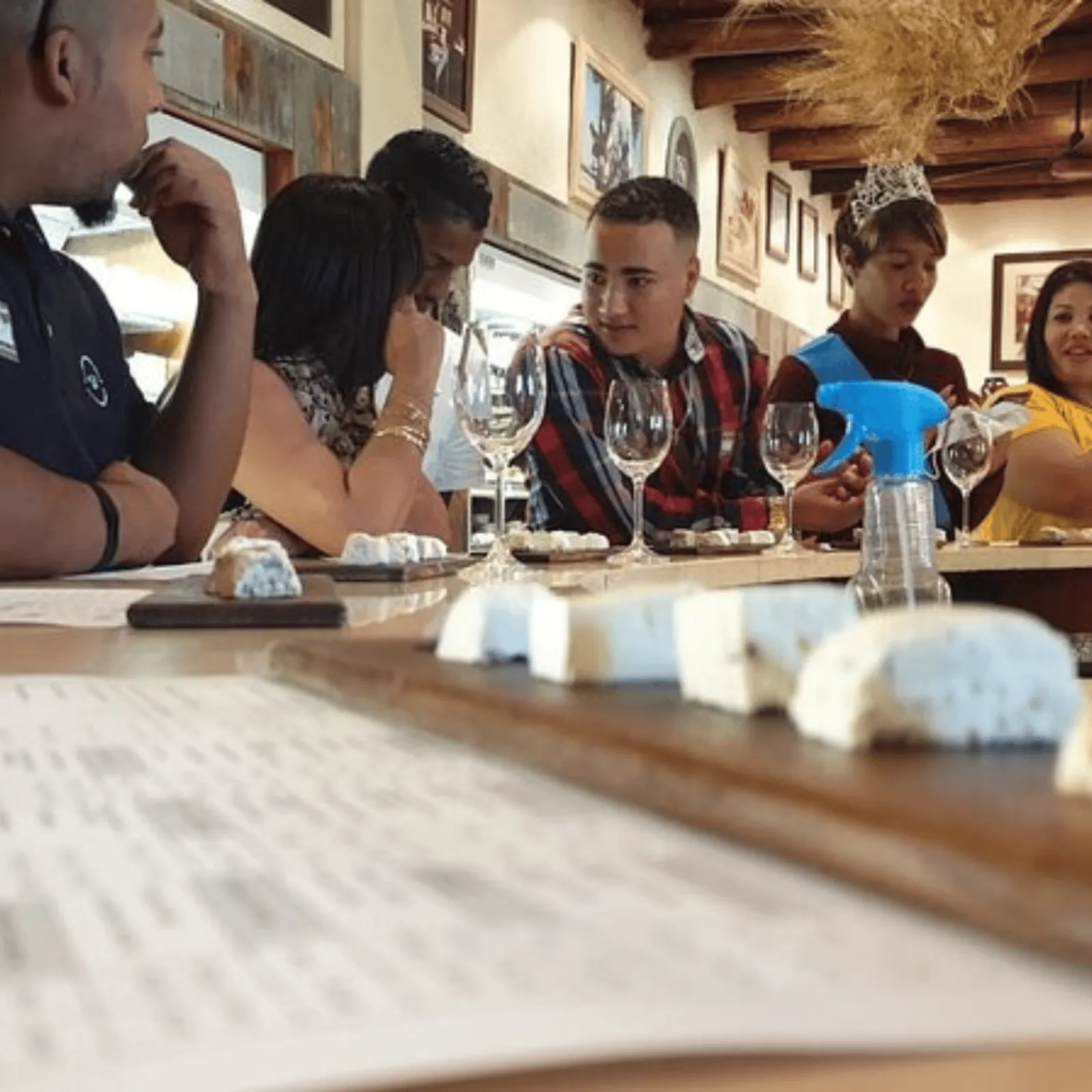 Guests tasting wine at a counter with cheese pairings laid out in front of them