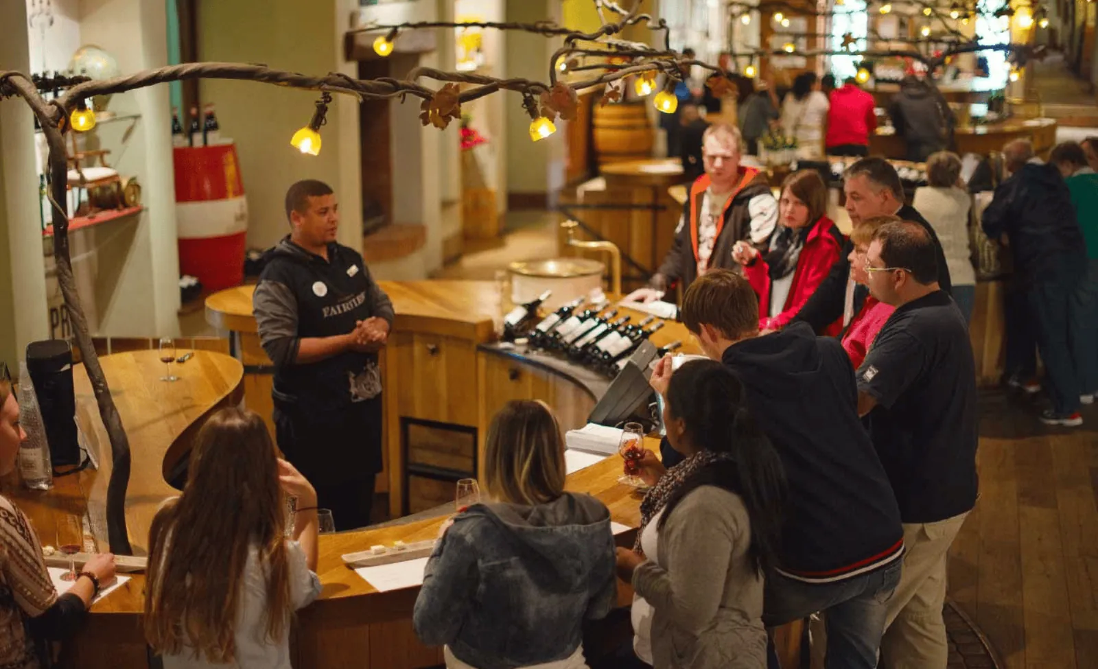 A busy Stellenbosch tasting room with guests gathered around the counter