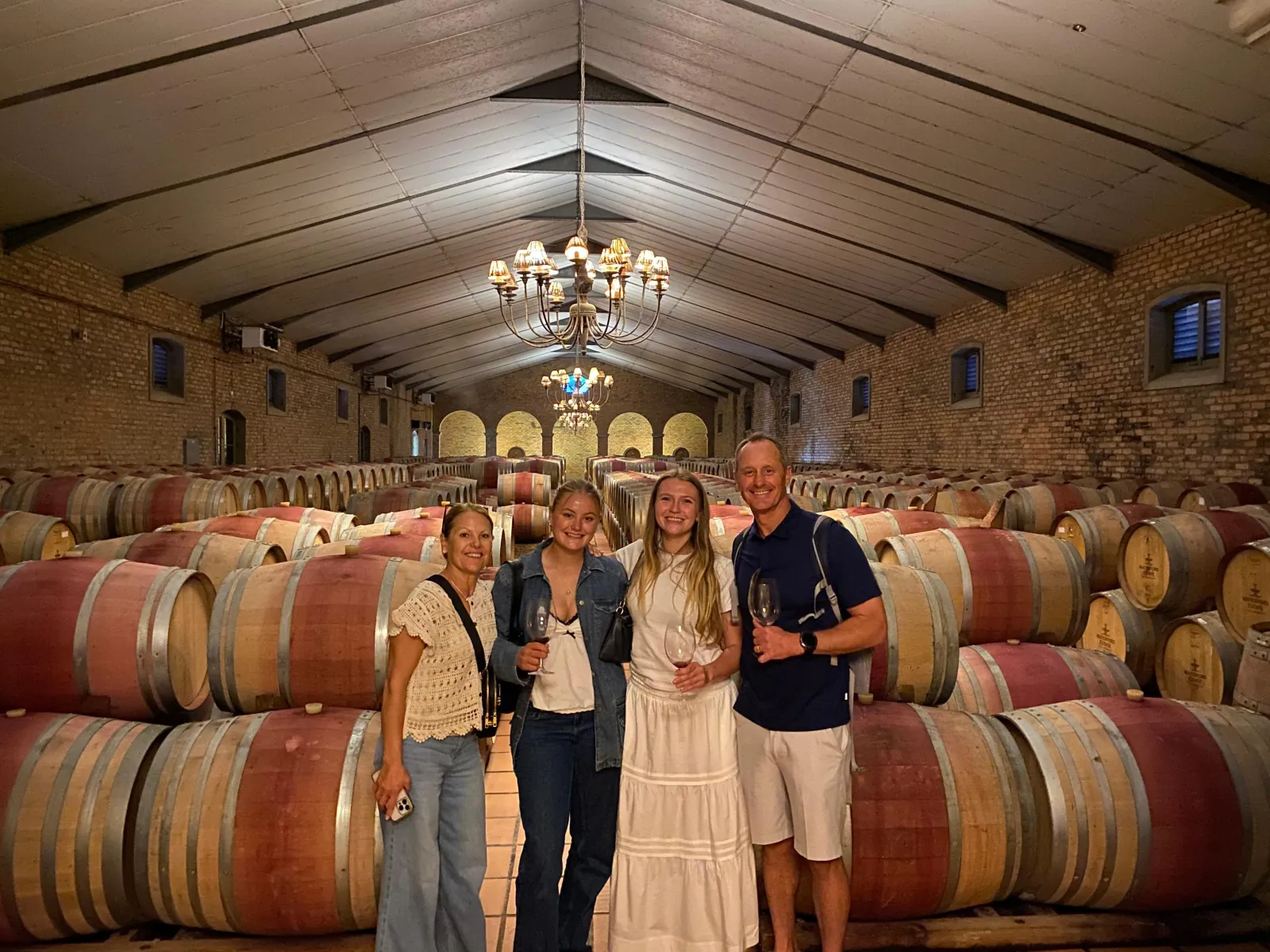 Guests on a private cellar tour among the oak barrels